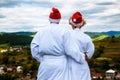 Happy ÃÂouple in a white coat and Santa Helper Hats on the mountain